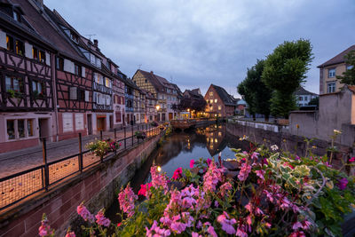 View of canal amidst buildings against cloudy sky