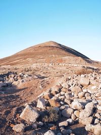 Scenic view of desert against clear blue sky