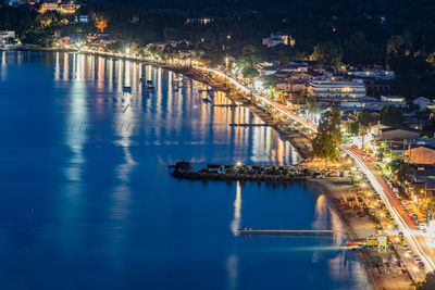 Illuminated bridge over river in city at night