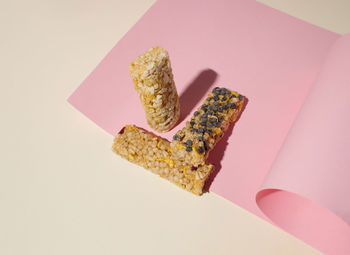 Energy bars on light pink and beige background. creative concept healthy food. high angle. 
