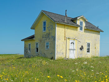 House on field against clear sky