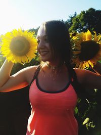 Close-up of young woman against sunflower