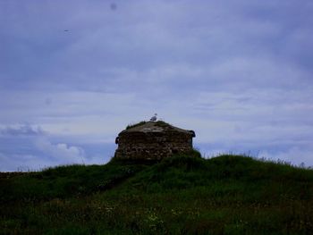 View of castle on landscape against cloudy sky