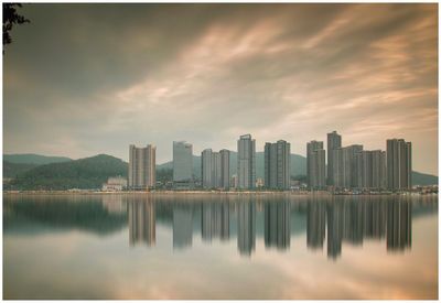 Reflection of buildings in city against sky