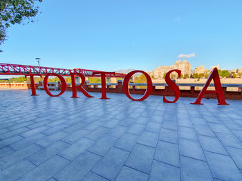 Low angle view of text on footpath against sky