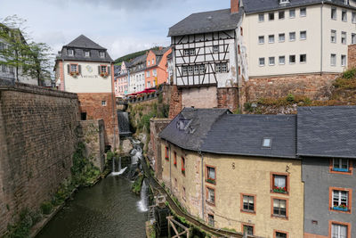 High angle view of canal amidst buildings in town