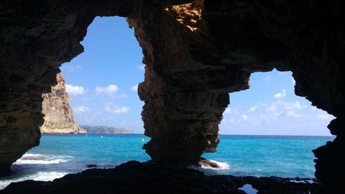 Scenic view of sea seen through cave