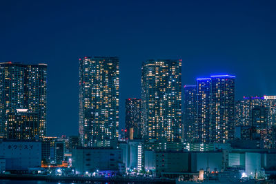 Illuminated buildings against sky at night