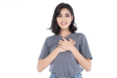 Portrait of a smiling young woman against white background