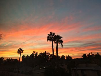 Low angle view of silhouette palm trees against sunset sky