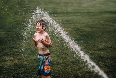 Full length of shirtless man standing in water