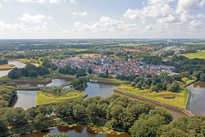 High angle view of townscape by river against sky