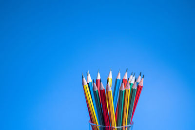 Close-up of multi colored pencils against blue background