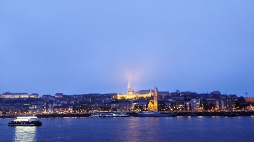 Illuminated buildings in city at waterfront