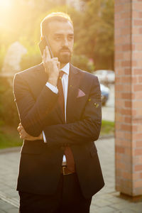 Businessman talking on mobile phone on footpath