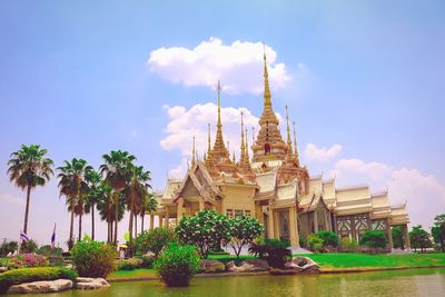 Mahawiharn temple by pond against sky