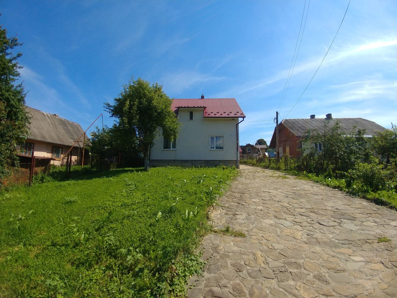 building exterior, built structure, architecture, building, sky, residential district, house, cloud - sky, nature, plant, grass, no people, day, tree, land, sunlight, city, green color, outdoors, field, cottage