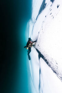 Side view of male scuba diver swimming by ice in lake baikal