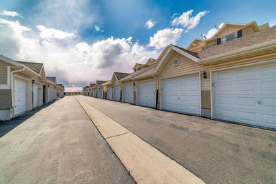 Footpath amidst buildings against sky