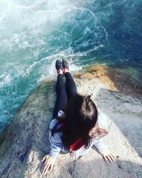 High angle view of woman sitting on rock 