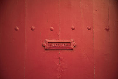 Red painted door with letter box, natural light, background