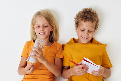 Portrait of smiling girl holding gift against white background