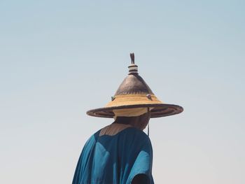 Rear view of man wearing hat against clear sky