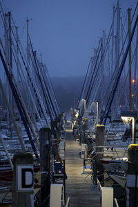 Sailboats on pier by sea against clear sky