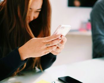 Close-up of woman using smart phone in office