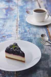 Coffee cup and cake on table