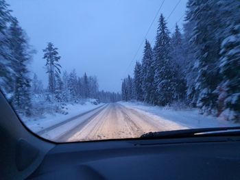 Road seen through car windshield during winter