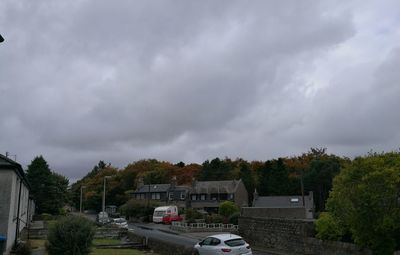 High angle view of vehicles parked on road against cloudy sky