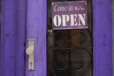 Open sign hanging on purple door