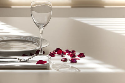 Plate with napkin and wineglass on table