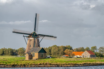 Traditional windmill on field against sky