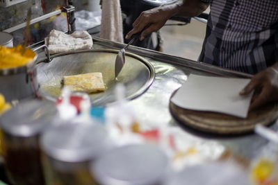 Midsection of man preparing food in kitchen