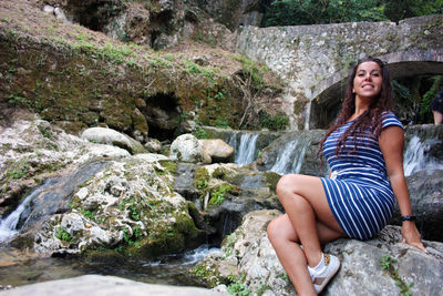 Young woman sitting on rock