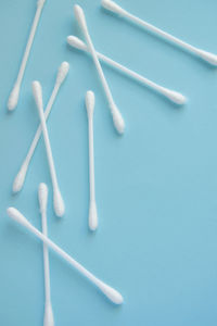 Directly above shot of cotton swabs on blue backgrounds