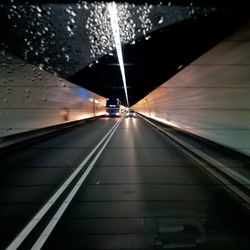 Illuminated road against sky at night