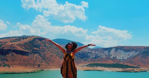 Woman standing against lake and sky