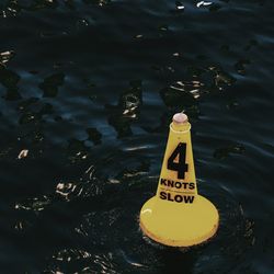 High angle view of yellow traffic cone in lake