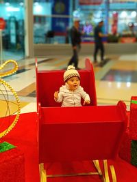 Cute boy sitting in toy at amusement park