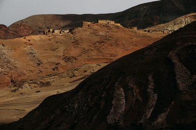 Scenic view of arid landscape and mountains against sky