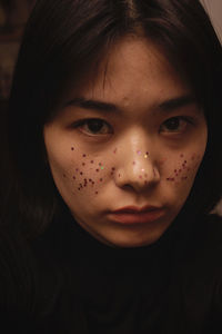 Close-up portrait of woman with glitter on face