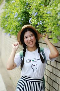 Portrait of smiling woman standing against plants