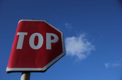 Low angle view of road sign against blue sky