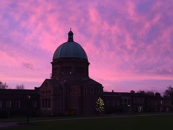 Buildings against cloudy sky at sunset