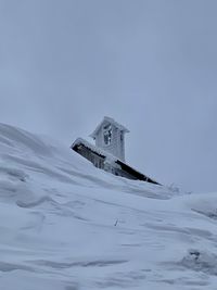 Built structure on snow covered building against sky