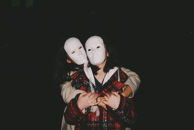Midsection of man and woman standing against black background