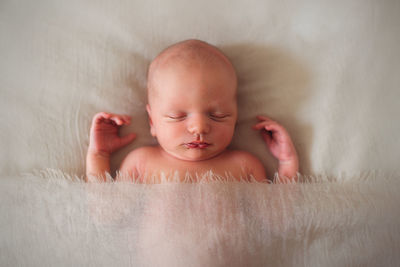 View from above of baby newborn sleeping covered with a blanket